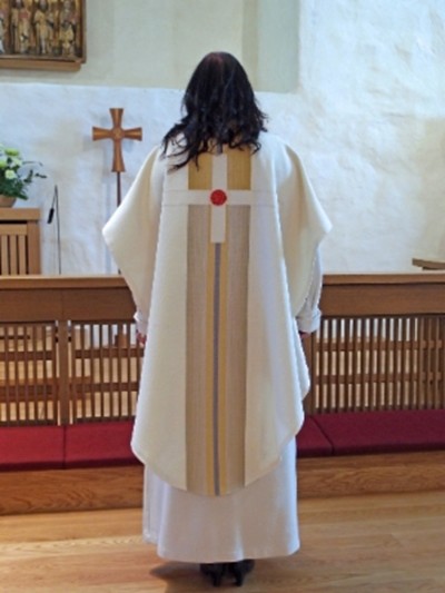 Valkoinen kasukka. Symboleina punainen ruusu, valo, vesi ja risti.