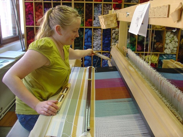 Taidekutoja Sanna Reinikainen kutomassa mallitilkkuja kaikkiin värisarjoihin. 