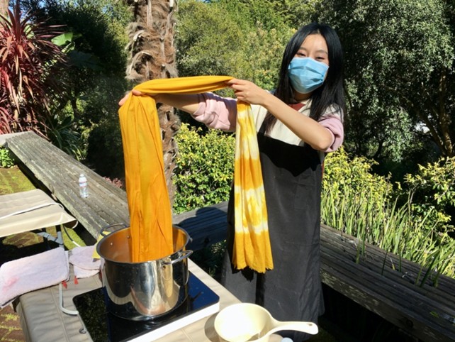 Työtilat ovat ulkona. Asiakas värjää Osage orange -puun purulla. Kuva: Auli Sookari